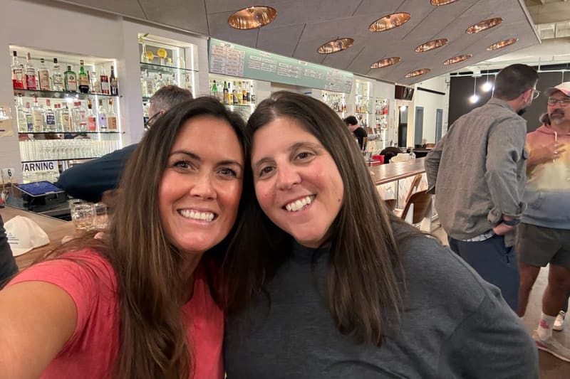 Two friends laughing together at the post-tournament gathering