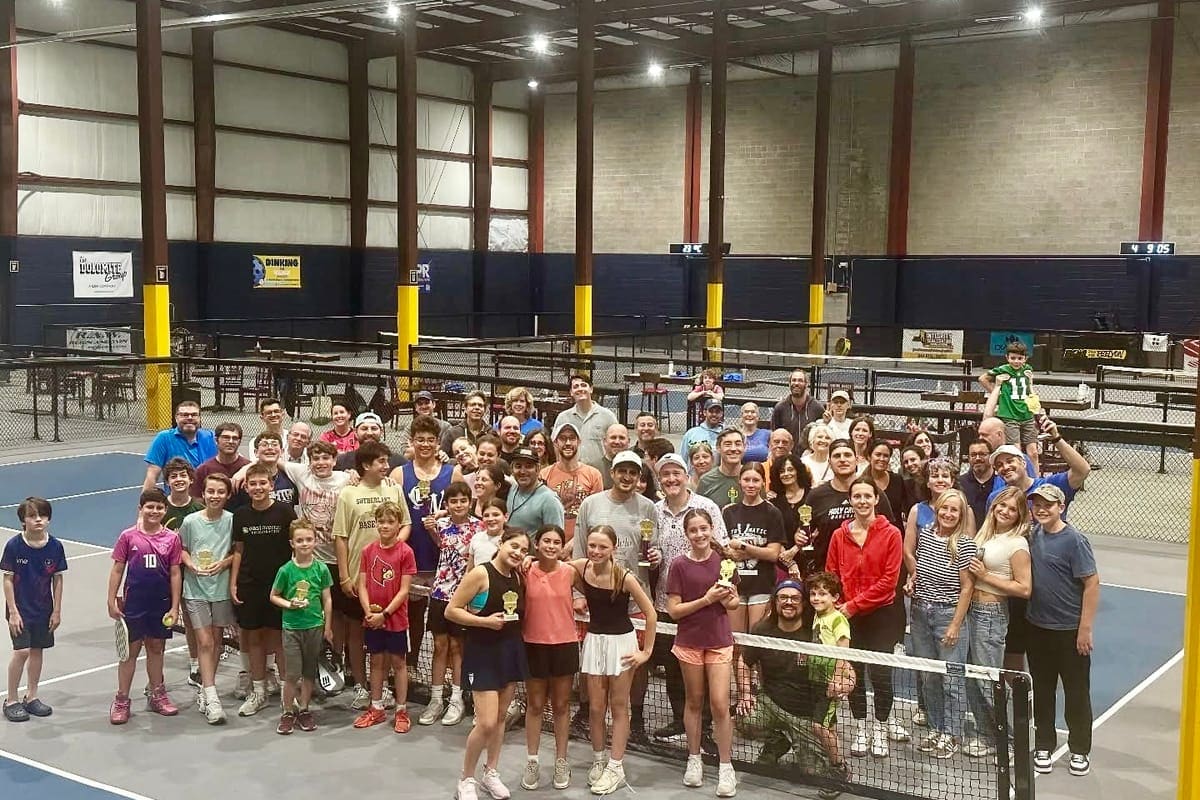 The full Be Like John Boyd field gathered together on the pickleball courts